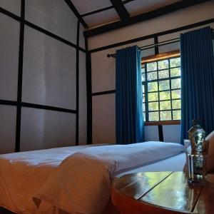 a bedroom with a bed and a table and a window at EarthShip Log Cabin, Timau in Nanyuki +8 photos