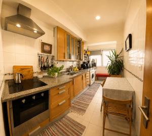 a kitchen with wooden cabinets and a table in it at Parque das Nações Room in Lisbon