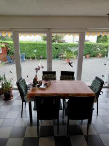 a dining room with a wooden table and chairs at KATA VENDÉGHÁZ in Balatonfüred +18 photos