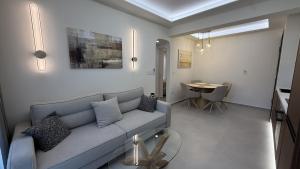 a living room with a gray couch and a table at Loutraki Sea Breeze Sunset Apt in Loutraki