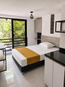 a bedroom with a bed and a desk in a room at Qantic Lodging & Rooftop in Medellín