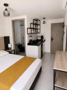a hotel room with a bed and a kitchen at Qantic Lodging & Rooftop in Medellín