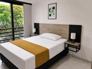 a bedroom with a large bed and a balcony at Qantic Lodging & Rooftop in Medellín +61 photos