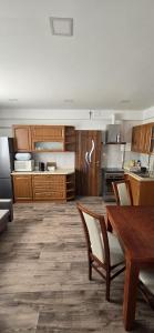 a kitchen with wooden cabinets and a table with chairs at Apartament WLA in Barcice