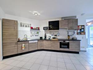 a large kitchen with wooden cabinets and appliances at Welcome in Weilerbach in Weilerbach +9 photos