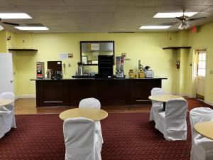 a room with tables and white chairs and a counter at A Red Dot Inn in Milledgeville