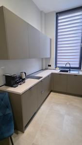 a kitchen with white cabinets and a sink and a stove at Motty Residence in Vicovu de Sus