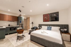 a bedroom with a large bed and a kitchen at Zee Residence in Lagos