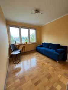 a living room with a blue couch and a chair at Strzelce in Strzelce Krajeńskie