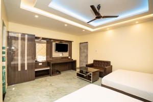 a bedroom with a bed and a ceiling fan at Mahabhoj Hotel & Restaurant in Mandarmoni