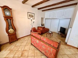 a living room with a couch and a grandfather clock at L'intemporel Chez Mémé - Centre - Saint Etienne in Saint-Étienne