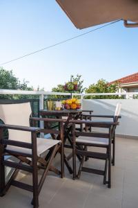 a wooden table and chairs on a balcony at vranas hotel in Skala Sotiros