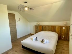 a bedroom with a bed with two stuffed animals on it at Le Balcon de Narlay in Le Frasnois