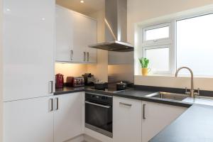 a kitchen with white cabinets and a sink and a window at North Parade Avenue in Oxford