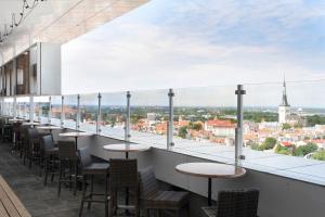 a balcony with tables and chairs and a view of a city at Original Sokos Hotel Viru in Tallinn