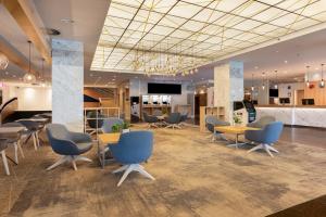 a waiting area with chairs and tables in a lobby at Original Sokos Hotel Viru in Tallinn +31 photos