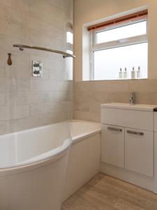 uma casa de banho branca com uma banheira e um lavatório em North Parade Avenue em Oxford