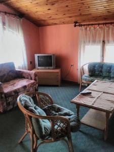 a living room with a couch a table and a tv at Bonbon Guest House in Panagyurishte