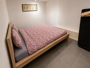 a bedroom with a bed with a purple blanket at Apart'Hotel Liège City Centre in Liège