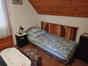 a small bedroom with a bed and a lamp at Pipacs ház in Balatonlelle
