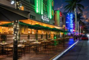 a restaurant with tables and chairs on a street at night at Beacon South Beach Hotel in Miami Beach