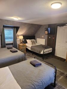 a hotel room with two beds and a tv at BELLFIELD HOUSE in Broadford