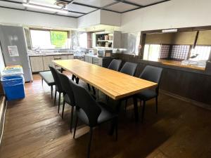 a dining room with a wooden table and chairs at Matsunokitei Chalet Irori in Otari +21 photos