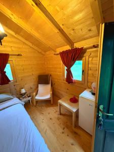 a bedroom in a log cabin with a bed and a chair at EtnoPetra in Mojkovac