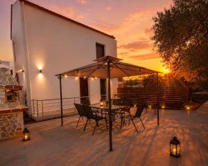 a patio with a table and chairs under an umbrella at Chrisella Crystal in Skala Rachoniou