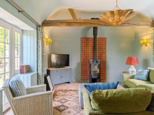 a living room with a couch and a tv at Brooks Farmhouse - Pulborough in Pulborough
