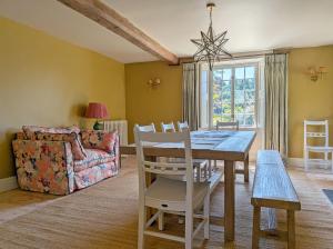 a dining room with a table and a couch at Brooks Farmhouse - Pulborough in Pulborough