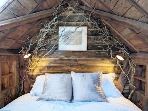 a bedroom with a bed with branches on the ceiling at Brooks Farmhouse - Pulborough in Pulborough +96 photos