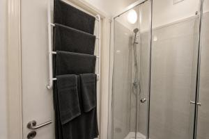 a bathroom with a shower and black towels at Apart'Hotel Liège City Centre in Liège
