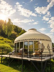 a gazebo with chairs in it on the grass at Ayu Eco Hotel in Karakol