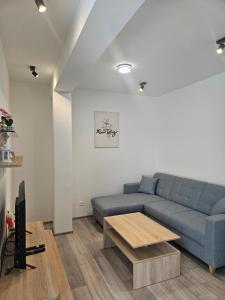 a living room with a blue couch and a table at Apartmány Koliba in Turčianske Teplice