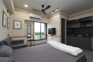 a living room with a bed and a tv at FLH Residences, Ambawadi in Ahmedabad