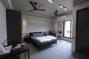 a bedroom with a bed and a couch and a table at FLH Residences, Ambawadi in Ahmedabad
