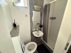 a small bathroom with a toilet and a sink at Gästehaus Kerle in Dossenheim +16 photos