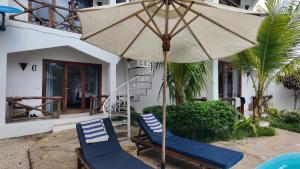 a couple of chairs and an umbrella in front of a house at Ocean view boutique in Nungwi