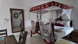 a bedroom with a canopy bed and a mirror at Ocean view boutique in Nungwi