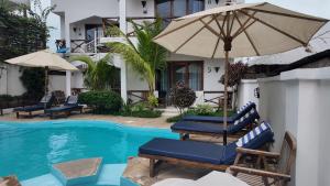a resort pool with chairs and an umbrella at Ocean view boutique in Nungwi