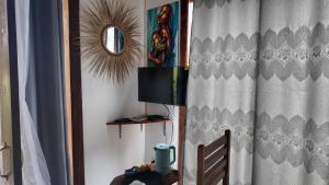 a room with a curtain and a television and a mirror at Ocean view boutique in Nungwi