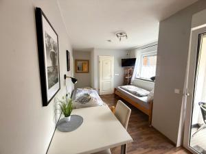 a small apartment with a table and a bedroom at Gästehaus Kerle in Dossenheim