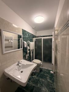 a bathroom with a sink and a toilet and a shower at Boutique Hotel Washington Milano - JCUBE HOTELLERIE in Milan
