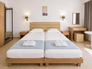 a bedroom with a bed with two towels on it at Agnes Beach Hotel Apartments in Kavos