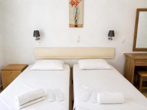 two beds sitting next to each other in a room at Agnes Beach Hotel Apartments in Kavos