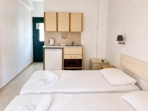 two beds in a small room with a kitchen at Agnes Beach Hotel Apartments in Kavos +23 photos