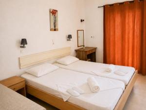 a bedroom with two beds and a orange curtain at Agnes Beach Hotel Apartments in Kavos