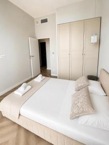 a bedroom with a large white bed with two towels at Nad Zatoką Apartament 340 in Olsztyn
