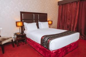 a hotel room with a large bed and a chair at Hotel Vip Grand Maputo in Maputo +30 photos